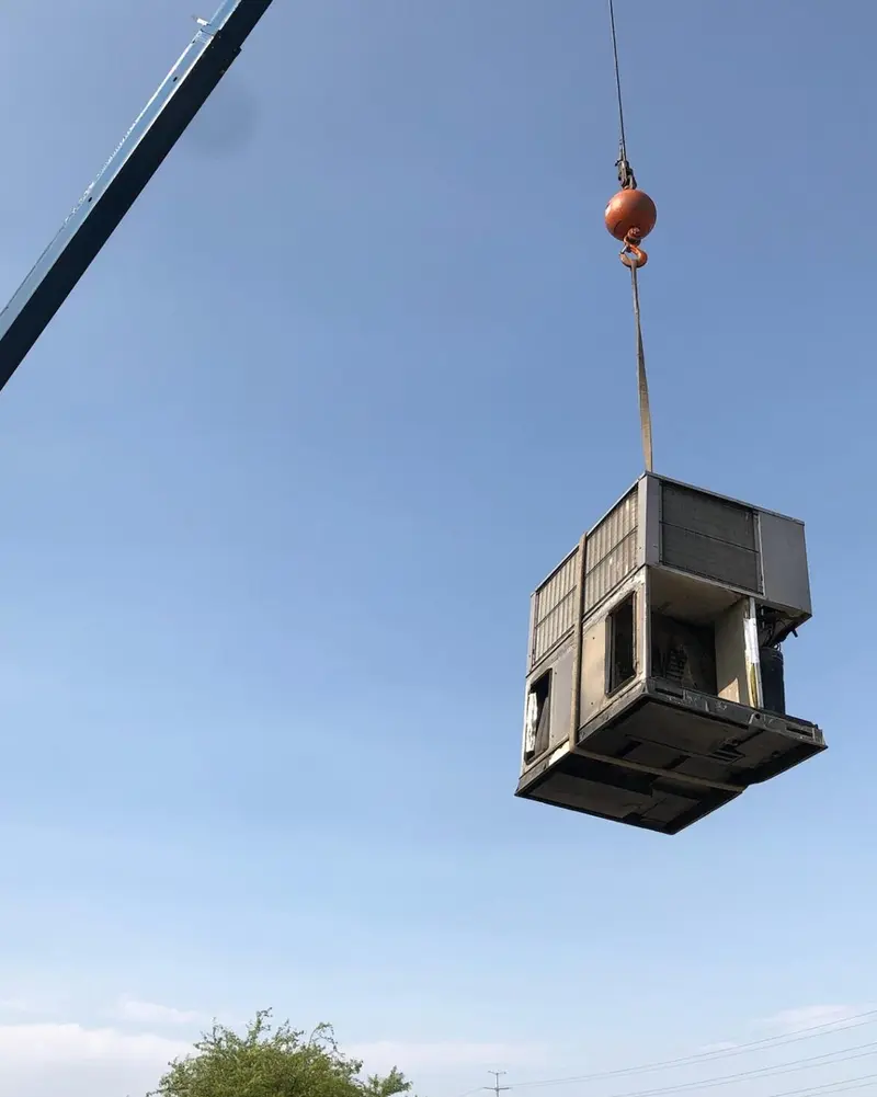Crane lifting commercial HVAC unit for rooftop installation in Las Vegas