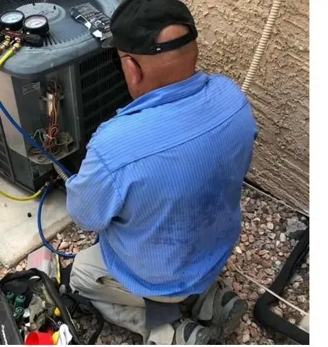 We Care Air technician testing refrigerant pressures on a Henderson home AC unit