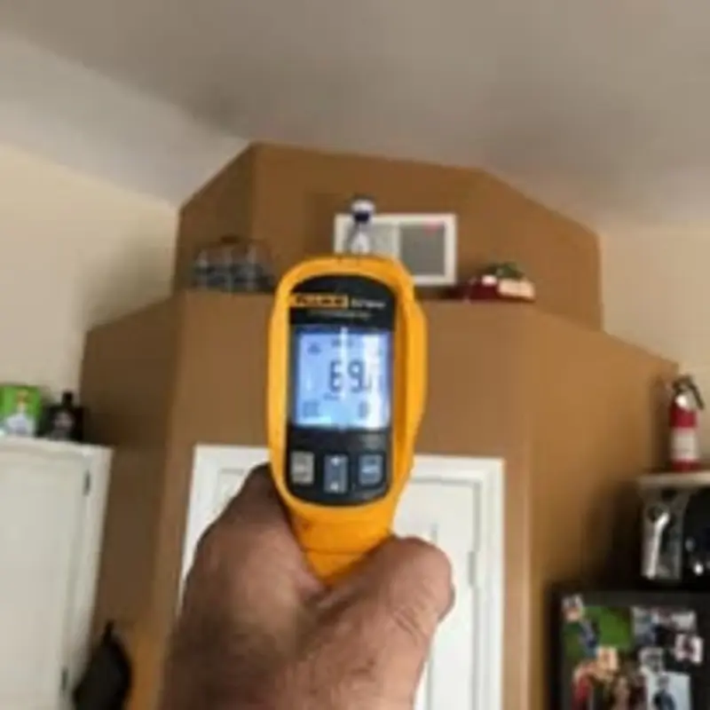 Fluke infrared temperature gun checking vent output during Las Vegas HVAC inspection